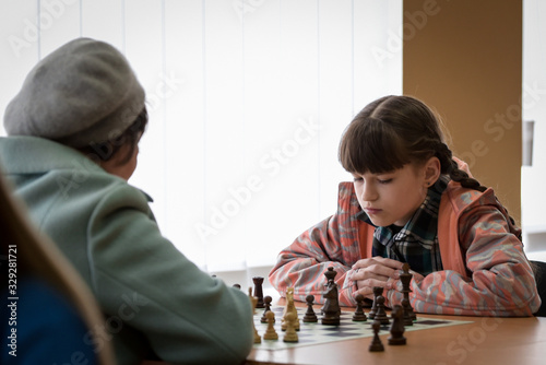 A teenage girl plays a chess game with an experienced woman. Game of chess. Chess tournament