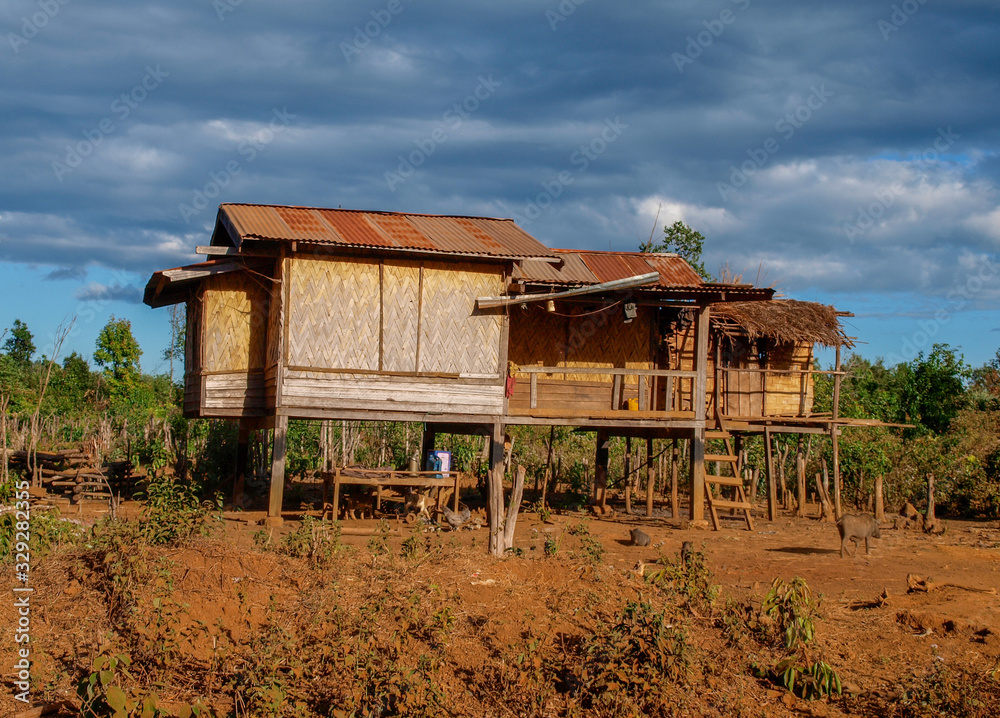 Traditionelle Hütten in typischer Bauweise aus Holz auf Stelzen in einem Dorf in Laos, Südostasien