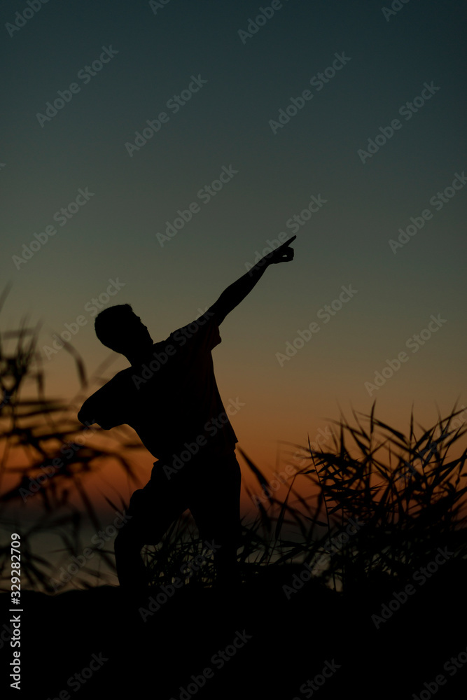 Silhouette on the Adriatic sea of a boy raising his arms Silhouette on the Adriatic sea of a boy raising his arms