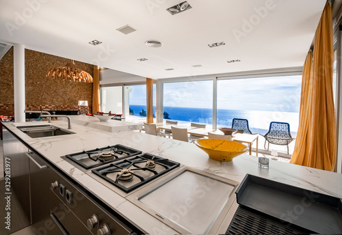 Modern marble countertop, gas stove and grill in a luxury kitchen with sea view.