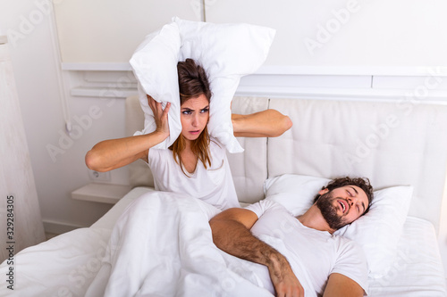 Fotografía Man snoring while his wife is covering ears with pillow