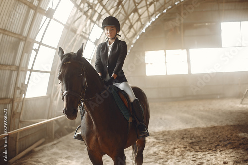 Woman on a horseback. Rider in a black uniform © prostooleh