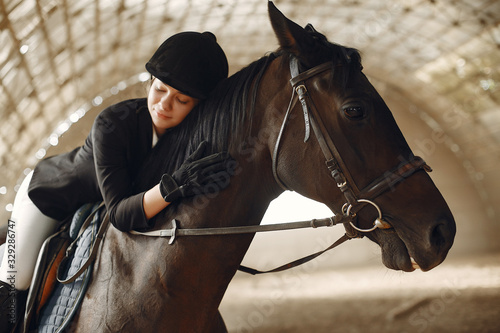 Woman on a horseback. Rider in a black uniform