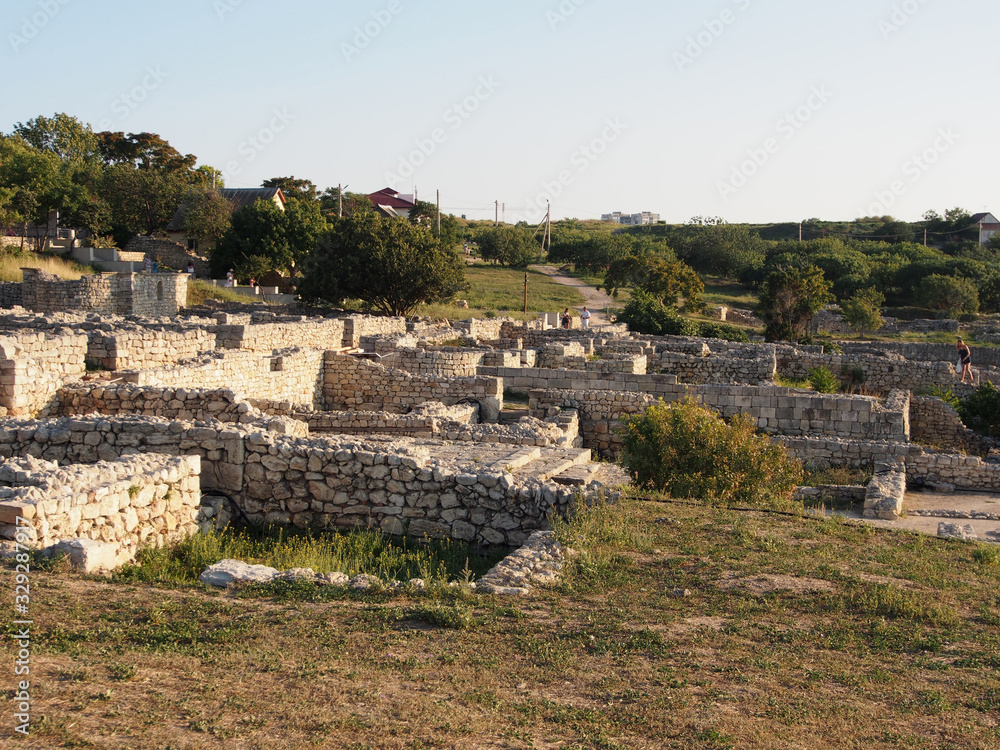 Ruins of the ancient city of Chersonesos dated to the stone foundations against the sea and blue sky.