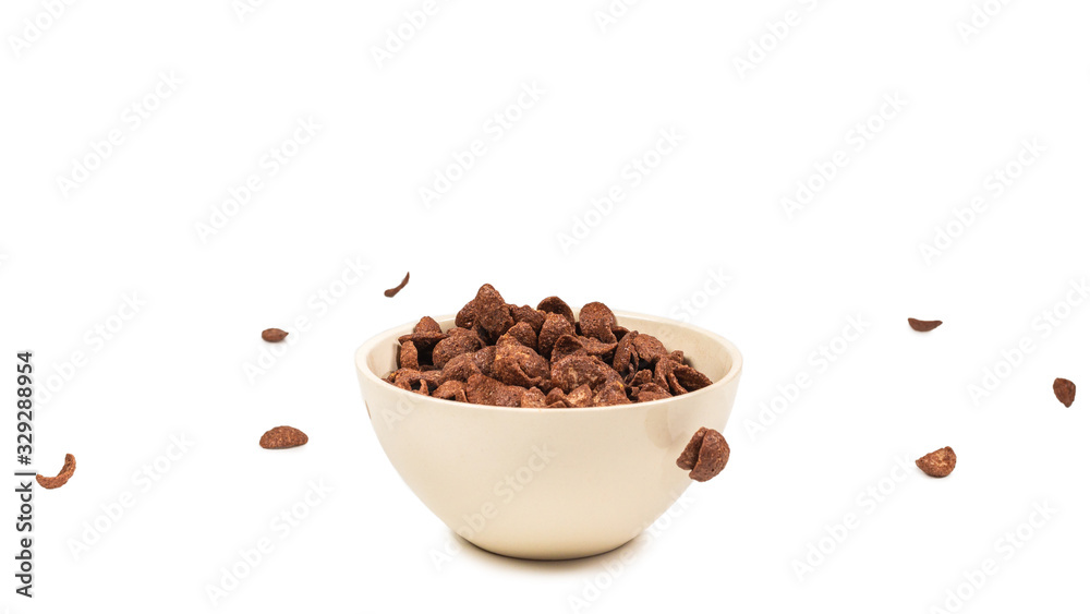 Chocolate corn flakes falling to the white bowl isolated on white. Motion. Chocolate corn flakes falling to the white bowl isolated on white. Motion.