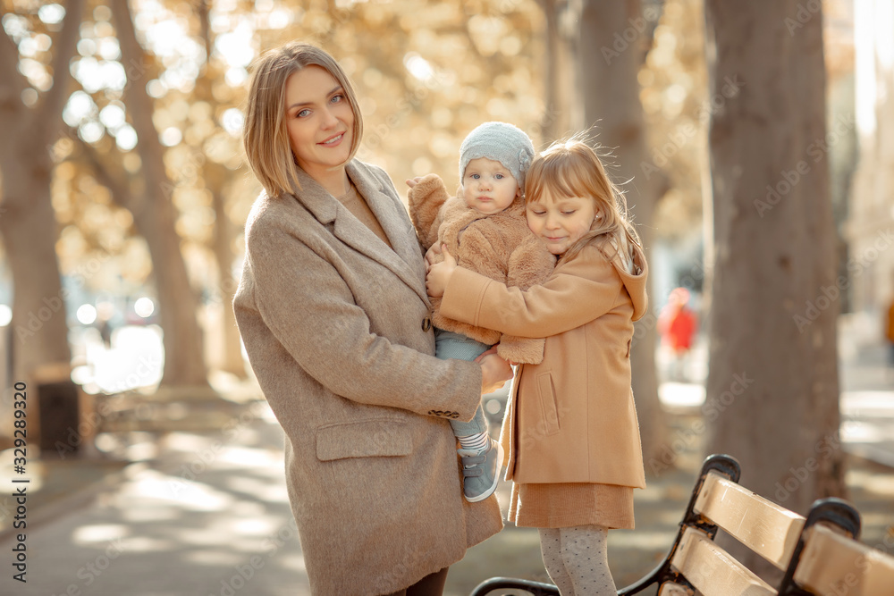Fototapeta premium Mother and child on a walk in a public park hugs and kisses