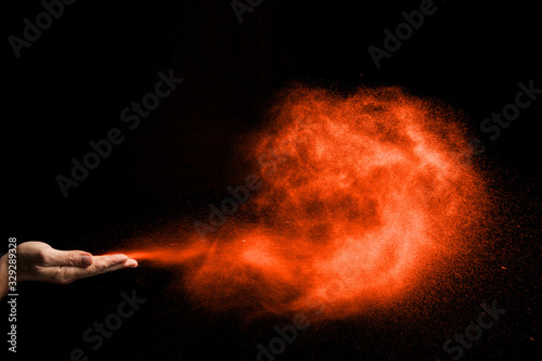 dust blows from hands on black background. color Lush Lava