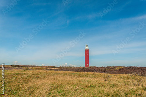 Red painted brick lighthouse Het Westhoofd in the North Sea dunes near the village of Ouddorp, municipality of Goeree-Overflakkee, South Holland, Netherlands. The tower was commissioned in 1950.