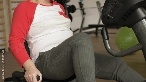 Middle aged woman with excess weight working out on stationary bike