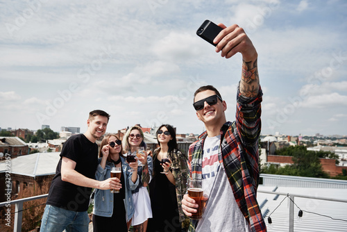 Photography Young friends drinking beer, taking selfie and having fun on the rooftop, copy space