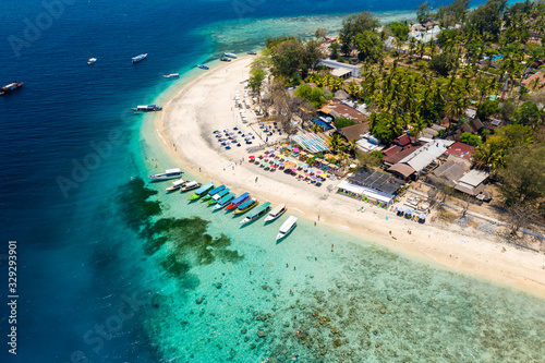Aerial drone view of boats around a tropical coral reef and beach on a small island © whitcomberd