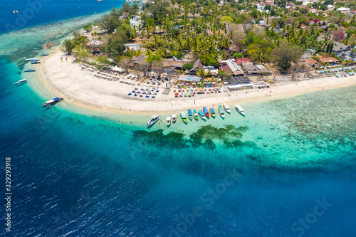 Aerial view of boats moored off a beautiful tropical coral reef and beach on a small island (Gili Air, Indonesia) photo