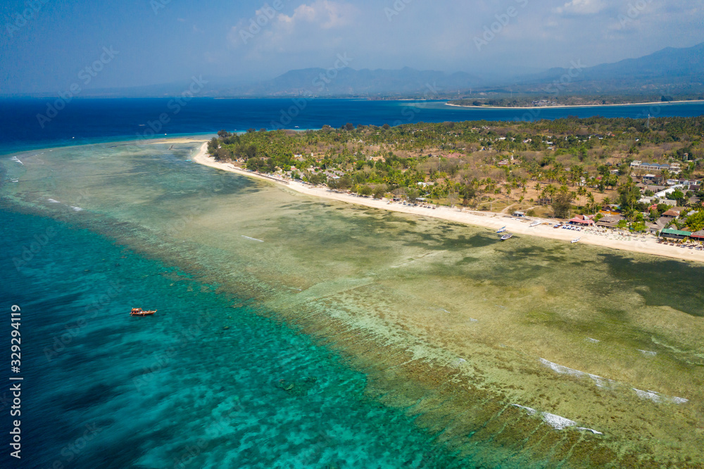 Aerial drone view of a beautiful tropical beach and coral reef on a small island (Gili Air, Indonesia)