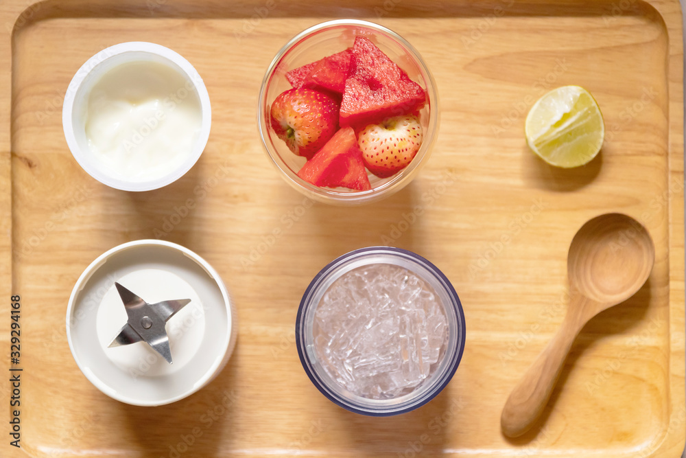 Healthy fruits with portable blender on wooden tray getting ready for making a smoothie. Fresh strawberry and watermelon with ice; healthy and fresh concept. Healthy fruits with portable blender on wooden tray getting ready for making a smoothie. Fresh strawberry and watermelon with ice; healthy and fresh concept.