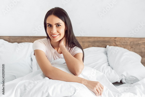 Bedtime. Woman sitting in bed smiling happy