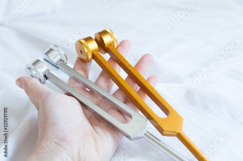 Slika na platnu Hand holding a tuning fork and crystal stone  .