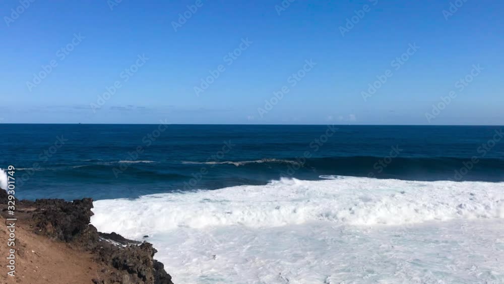 Forming large waves on the sea surface of blue color and clear water from above view of the forming waves on the horizon and crashing into the coast in slow motion capture at 120fps. Forming large waves on the sea surface of blue color and clear water from above view of the forming waves on the horizon and crashing into the coast in slow motion capture at 120fps.