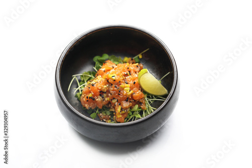 Fish tartare. Tasty raw fish tartare with avocado and sesame seeds, served on sprouts.
