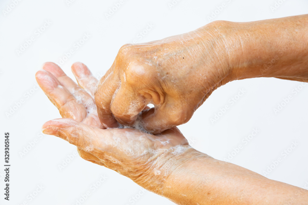 Senior woman's hands washing her hands using soap foam in step 6 on white background, Close up & Macro shot, Selective focus, Prevention from covid19, Bacteria, healthcare concept, 7 step wash hand Senior woman's hands washing her hands using soap foam in step 6 on white background, Close up & Macro shot, Selective focus, Prevention from covid19, Bacteria, healthcare concept, 7 step wash hand