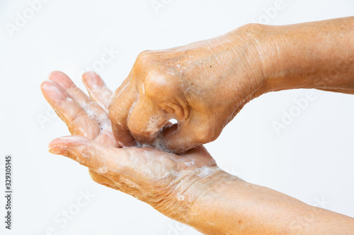 Senior woman's hands washing her hands using soap foam in step 6 on white background, Close up & Macro shot, Selective focus, Prevention from covid19, Bacteria, healthcare concept, 7 step wash hand