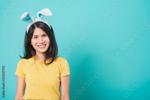 woman smile white teeth wear yellow t-shirt standing with bunny ears her looking to space