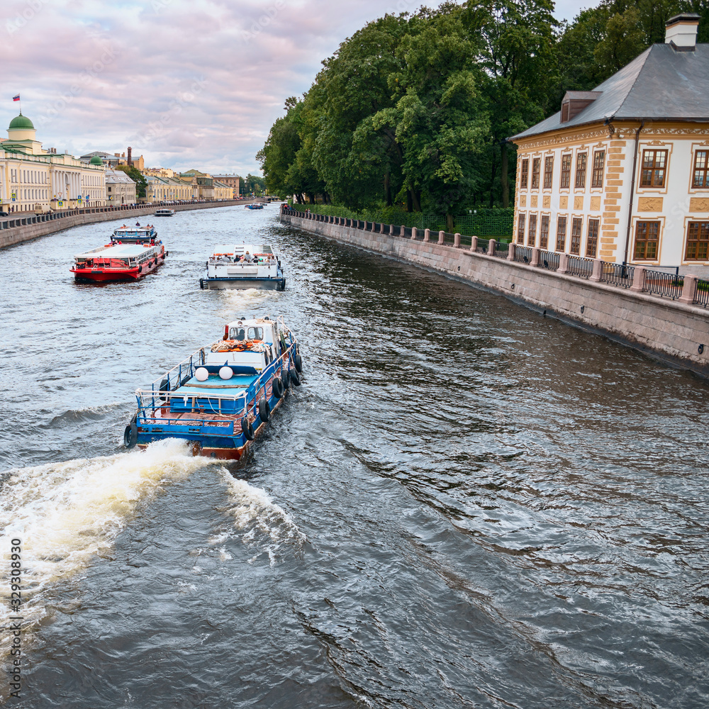 Naklejka premium View of the Fontanka River with pleasure boats and the embankment in St. Petersburg, Russia