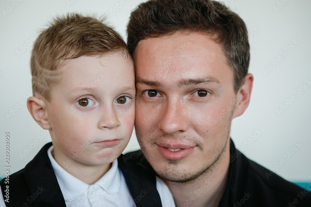 Man and a boy are sitting on a sofa. Man and a boy are sitting on a sofa.