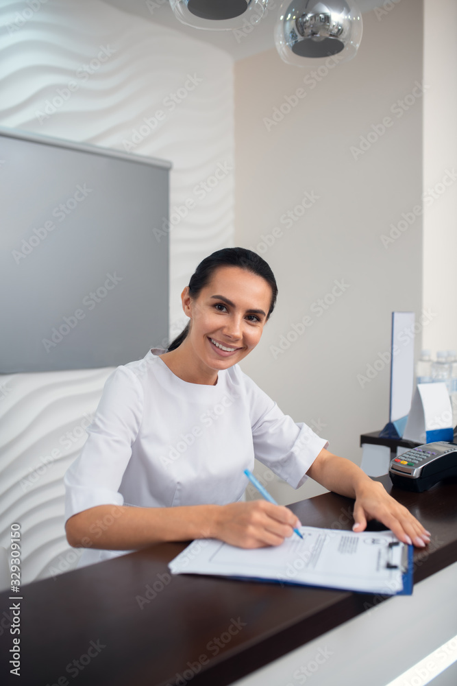 Cheerful manager of beauty clinic smiling while greeting clients