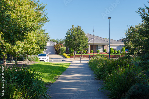 Photo A pedestrian footpath/walkway leads to residential houses in an Australian suburb