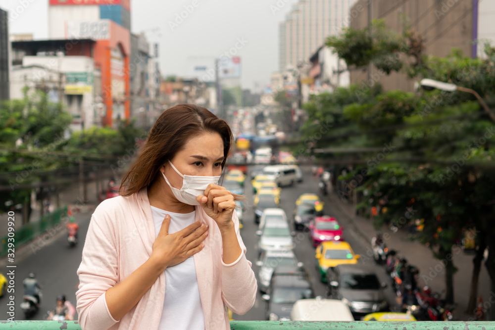 Portrait of young Asian girl wearing a mask in the city street. Prevent pollution and disease concept.