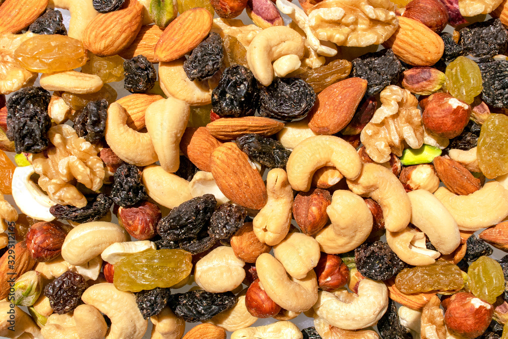 Background made of mixed nuts and raisins. Healthy snack and food. Cashew, almond, raisins, walnut, pistachio. Top view. Assorted nuts and dry grapes. Background made of mixed nuts and raisins. Healthy snack and food. Cashew, almond, raisins, walnut, pistachio. Top view. Assorted nuts and dry grapes.