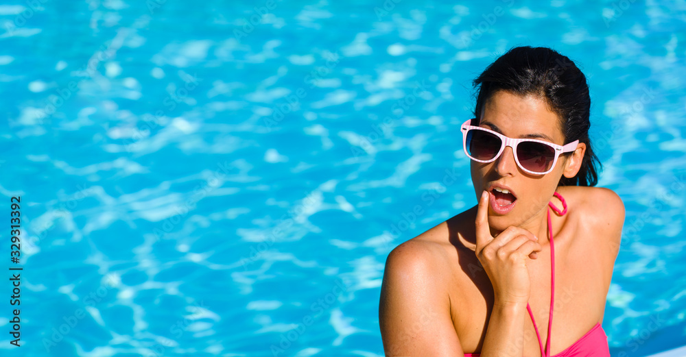 Surprised woman on summer vacation at swimming pool