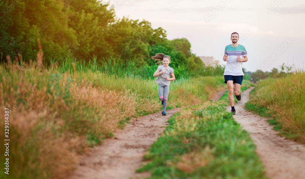 Father and daughter jogging. Cheerful father and daughter run in park together.