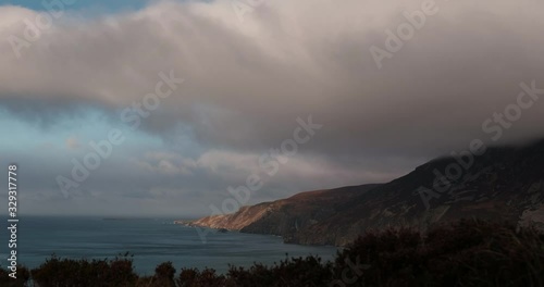 Scenic 4K video of Slieve League cliffs and Atlantic ocean with moving clouds in stormy weather, Donegal, Ireland