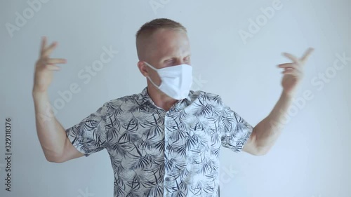 The young man defends himself against the 2020 virus coronavirus and other infections. He sits in a mask and shows bad and displeased emotions about the epidemic.