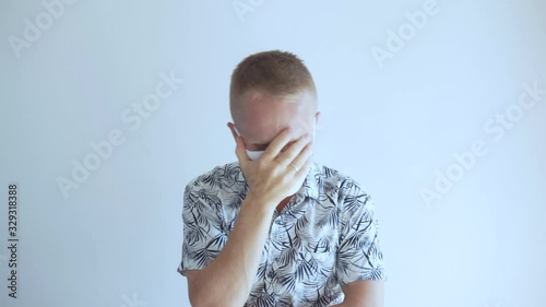 The young man defends himself against the 2020 virus coronavirus and other infections. He sits in a mask and shows bad and displeased emotions about the epidemic.