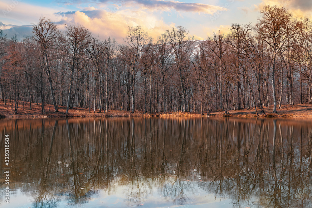 Beautiful spring sunset landscape. Forest on the lake, the trees reflacted on the water. Beautiful spring sunset landscape. Forest on the lake, the trees reflacted on the water.