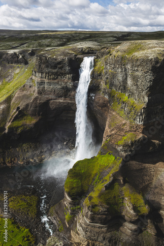 Aerial view of Haifoss big waterfall in south Iceland. Black high rocks  green hills and nobody around. Sunny summer weather.