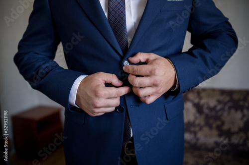 man in suit fastens button