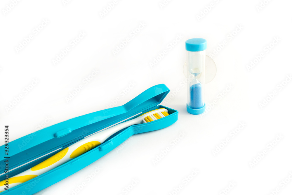 Toothbrush in a plastic case and dental Hourglass on white background Toothbrush in a plastic case and dental Hourglass on white background
