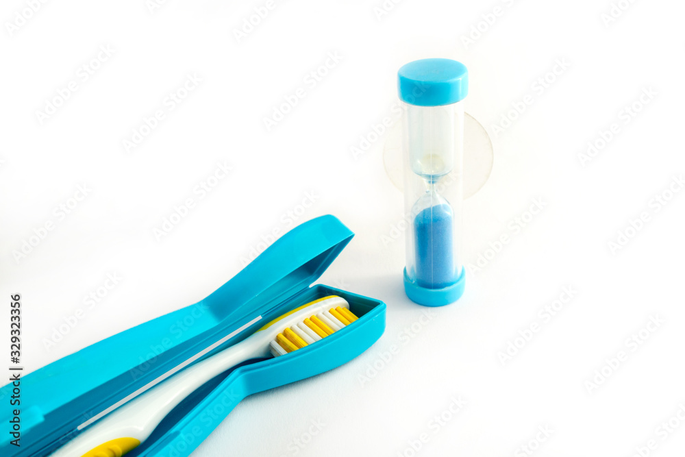 Toothbrush in a plastic case and dental Hourglass on white background Toothbrush in a plastic case and dental Hourglass on white background