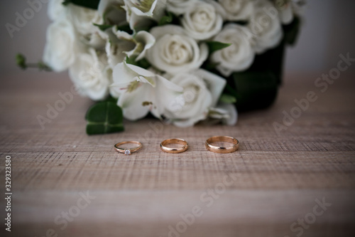 wedding rings on a table near a bouquet