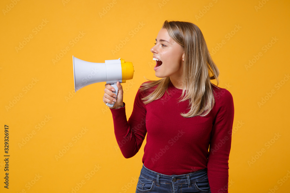 Young blonde woman girl in casual clothes posing isolated on yellow orange background studio portrait. People sincere emotions lifestyle concept. Mock up copy space. Scream in megaphone looking aside. Young blonde woman girl in casual clothes posing isolated on yellow orange background studio portrait. People sincere emotions lifestyle concept. Mock up copy space. Scream in megaphone looking aside.