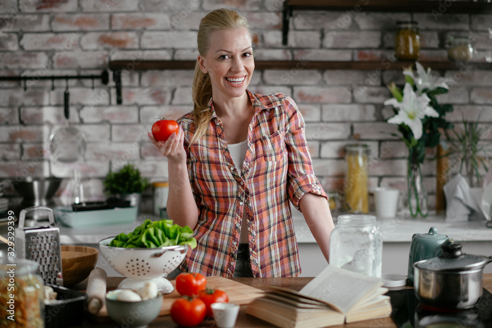 Young woman in kitchen. Beautiful woman making salad.	