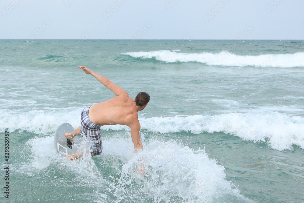 young man on a surfing board on the beach 