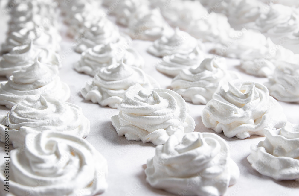 on a white pastel background lies a fresh white handmade marshmallow. copy space on a white pastel background lies a fresh white handmade marshmallow. copy space