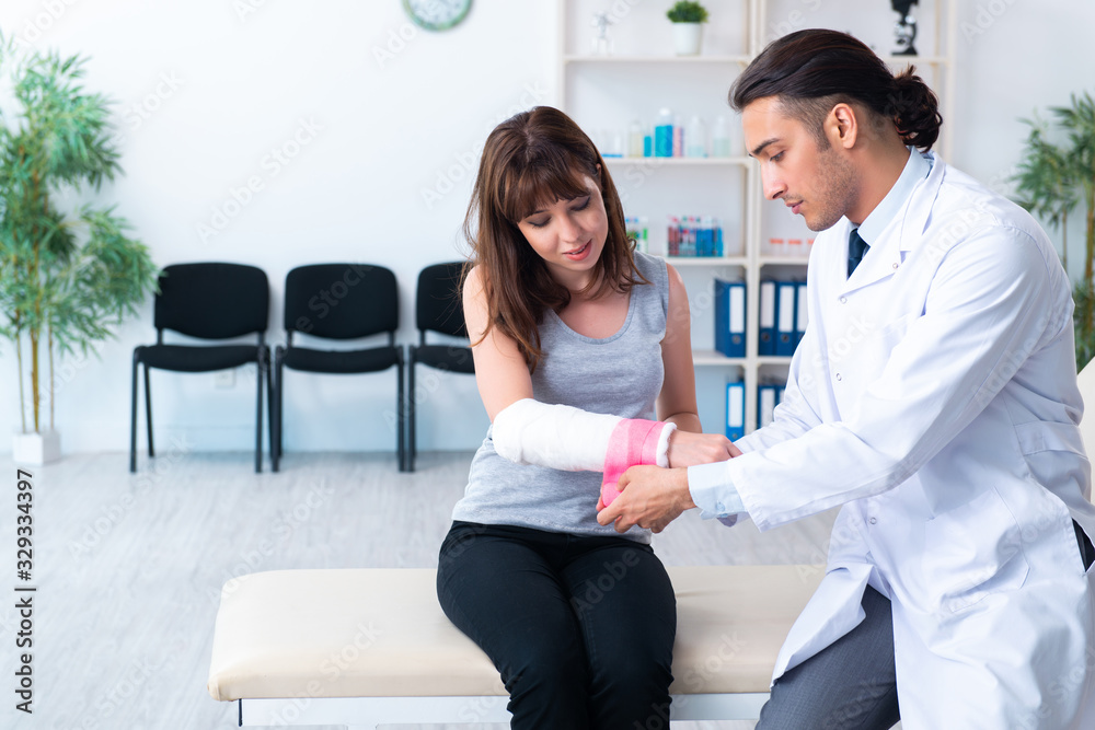 Young woman visiting male doctor traumatologist