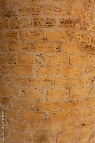 A fragment of an ancient wall of cylindrical shape made of stone. Creative vintage background.
