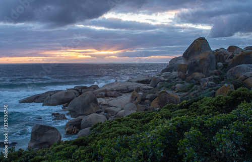 Sunset at local beach near Cape Town, waves crash against rocks