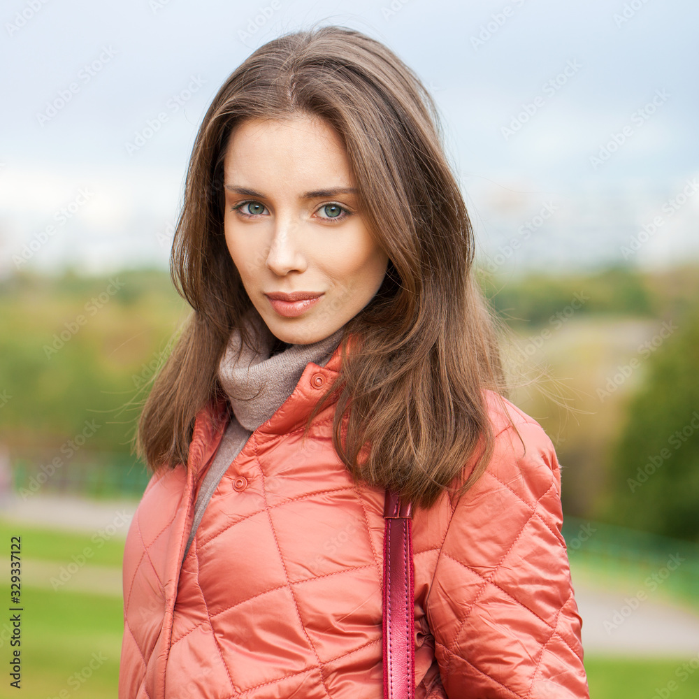 Close up portrait of a young beautiful brunette girl in coral coat Close up portrait of a young beautiful brunette girl in coral coat